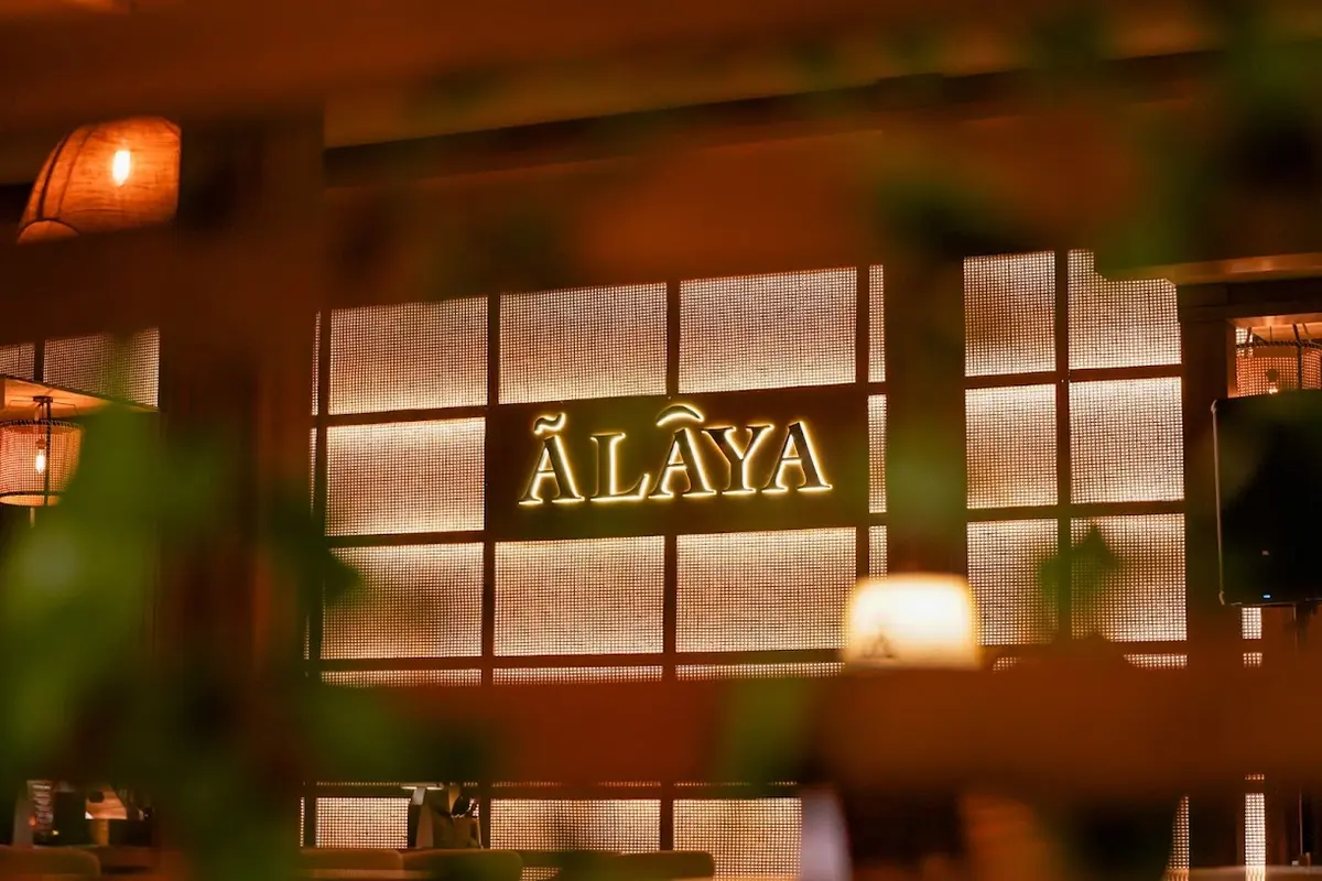 The illuminated Ālaya sign inside the bar